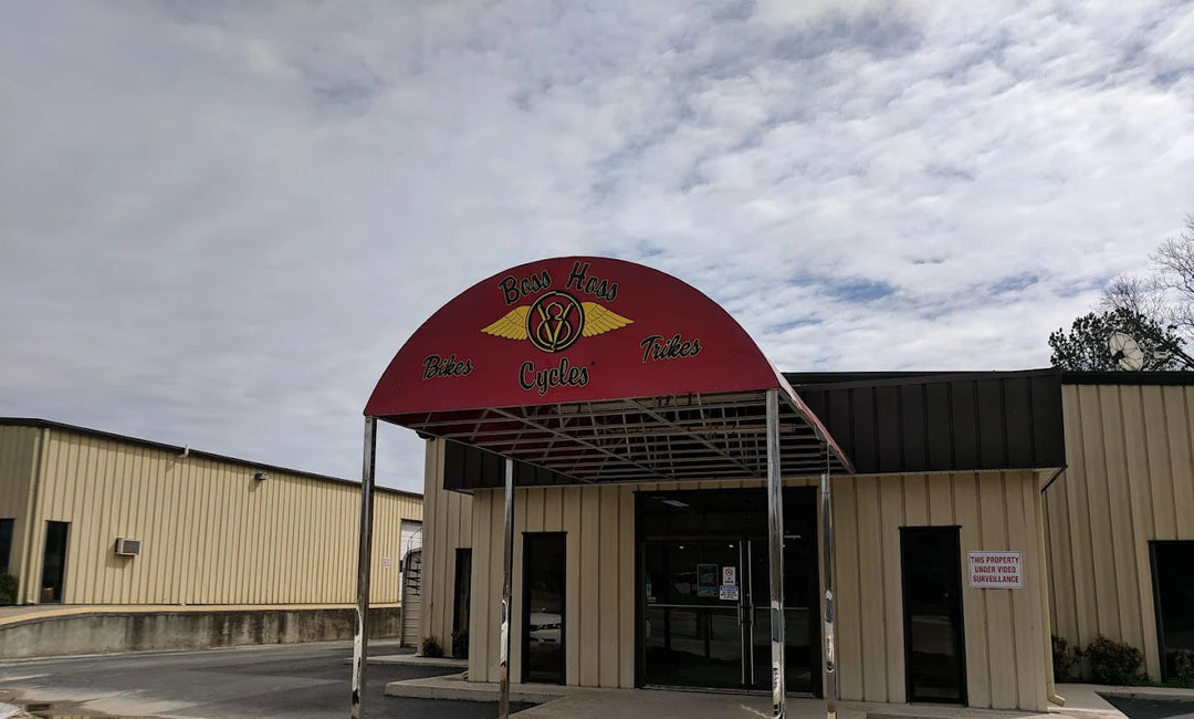 Commercial building entrance with a red canopy and logo under a cloudy sky